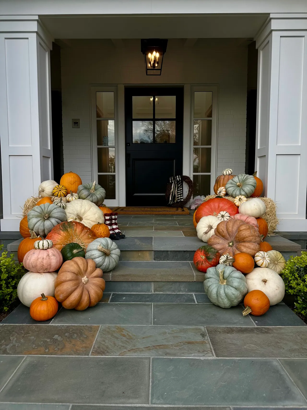 Heirloom pumpkins and straw bales styled on bluestone porch steps